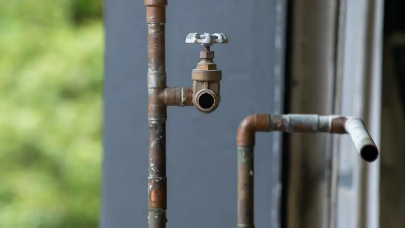 Conduites en cuivre oxydées et robinet-vanne à volant sur une installation