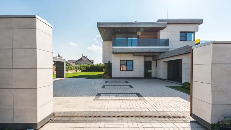 Maison contemporaine au bout d'une large entrée pavée encadrée de deux murets